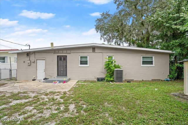 back of property with cooling unit and a yard