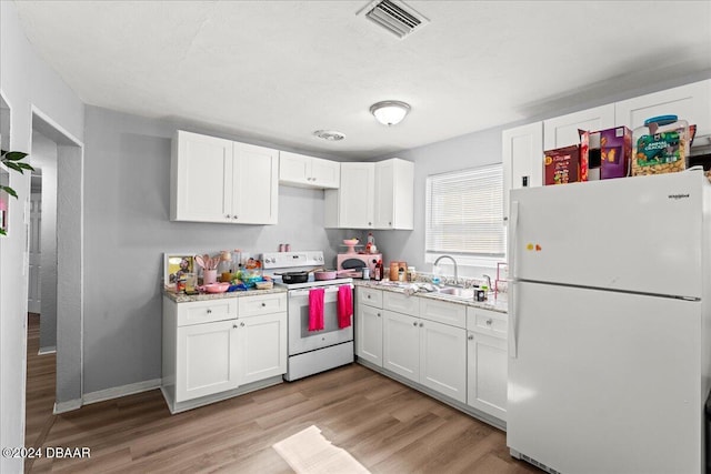856 Essex Rd, Daytona Beach, FL 32117 - kitchen featuring white appliances, white cabinets, light wood finished floors, a sink, and baseboards