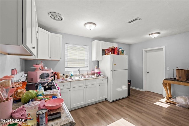 kitchen with white cabinetry, light hardwood / wood-style flooring, and white refrigerator