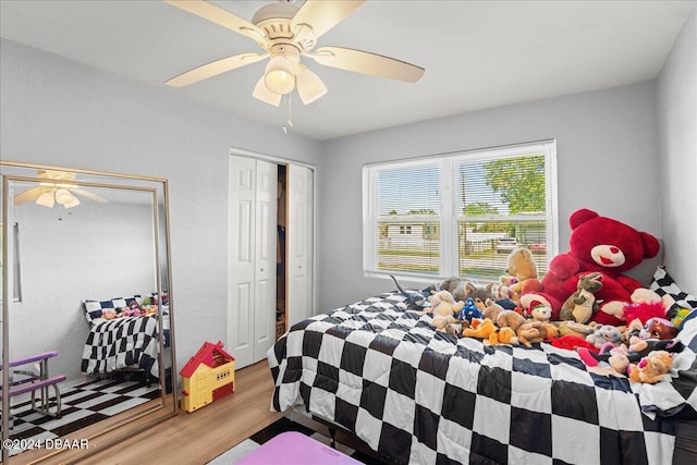 bedroom with a closet, light hardwood / wood-style floors, and ceiling fan