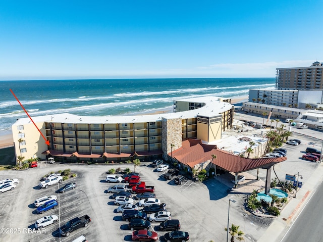 birds eye view of property featuring a beach view and a water view