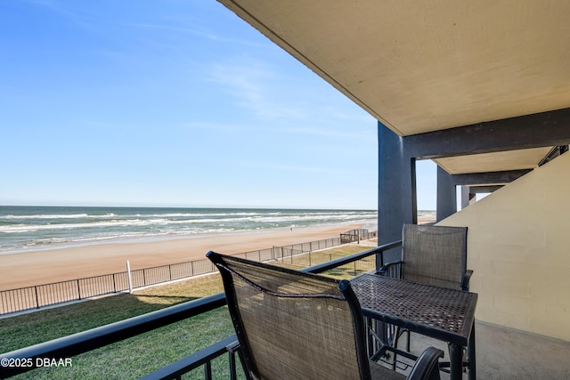 balcony featuring a beach view and a water view