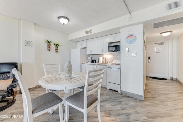 dining area with sink and a textured ceiling