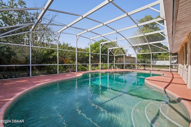 view of pool with a patio area and a lanai