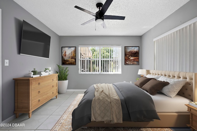 tiled bedroom with ceiling fan and a textured ceiling