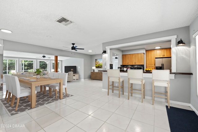 dining room with light tile patterned flooring, a textured ceiling, and ceiling fan