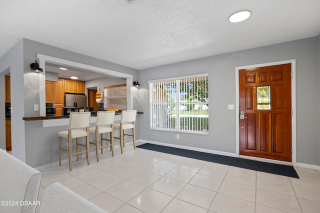 tiled entrance foyer with a textured ceiling