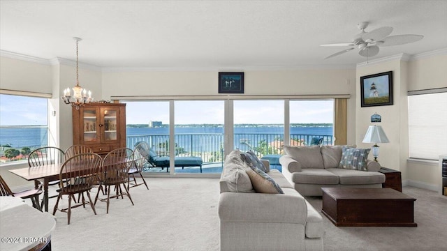 carpeted living room featuring ceiling fan with notable chandelier, a wealth of natural light, a water view, and crown molding