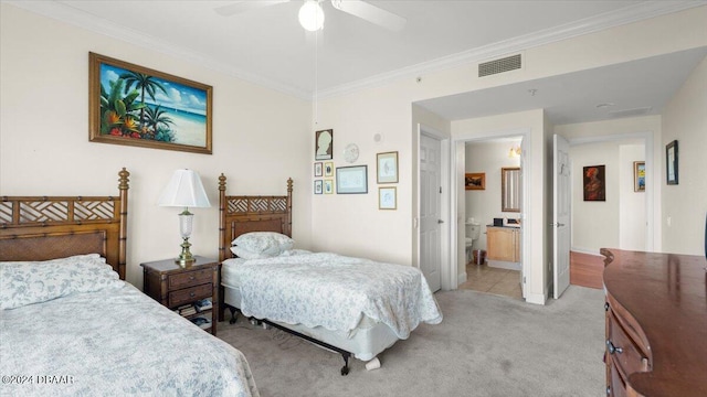 bedroom featuring ornamental molding, ensuite bath, light carpet, and ceiling fan