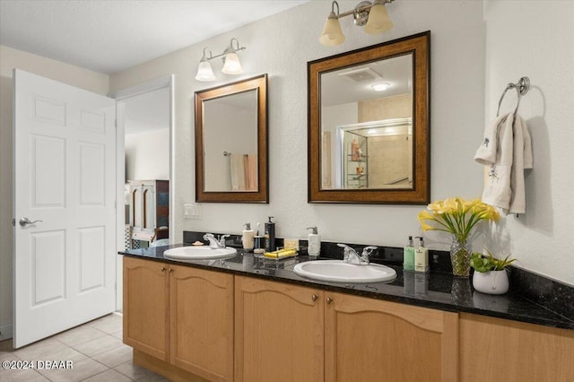 bathroom featuring vanity, a shower with shower door, and tile patterned floors