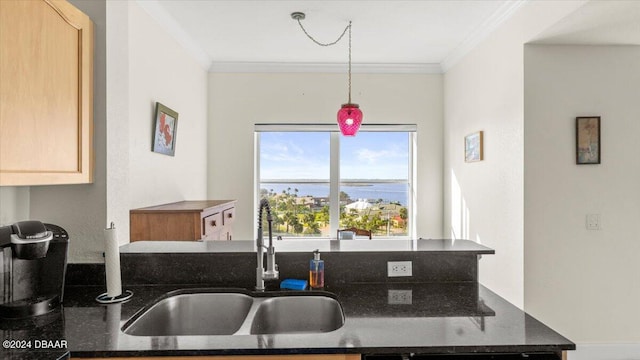 kitchen featuring a water view, pendant lighting, sink, ornamental molding, and light brown cabinets