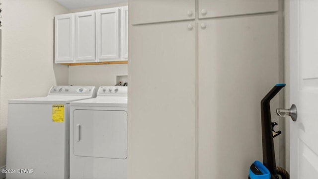 washroom with cabinets and washing machine and clothes dryer