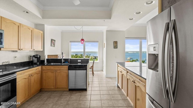 kitchen featuring stainless steel appliances, sink, a water view, plenty of natural light, and pendant lighting