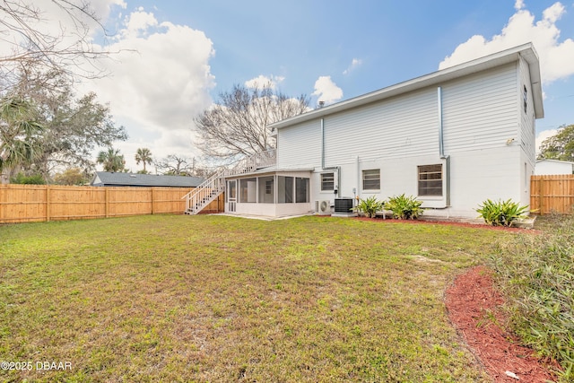 rear view of house with a sunroom, a fenced backyard, a lawn, and central air condition unit