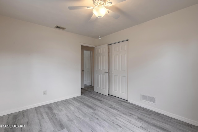 empty room featuring wood finished floors, visible vents, and baseboards