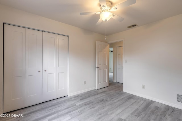 unfurnished bedroom featuring baseboards, a closet, visible vents, and light wood-style floors