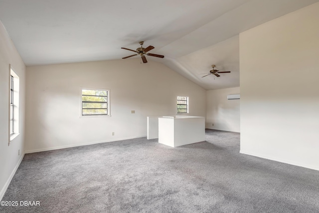 carpeted spare room with a ceiling fan, vaulted ceiling, and a wall mounted AC