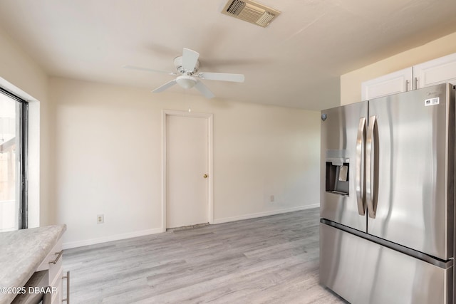 kitchen featuring stainless steel refrigerator with ice dispenser, light wood finished floors, light countertops, visible vents, and white cabinets