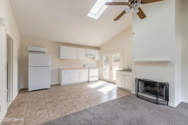 kitchen featuring light carpet, white appliances, a fireplace, white cabinets, and a wall mounted AC