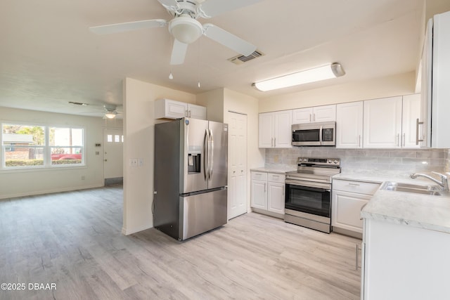 kitchen with tasteful backsplash, visible vents, stainless steel appliances, and a sink