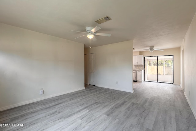 unfurnished room with ceiling fan, light wood finished floors, visible vents, and baseboards