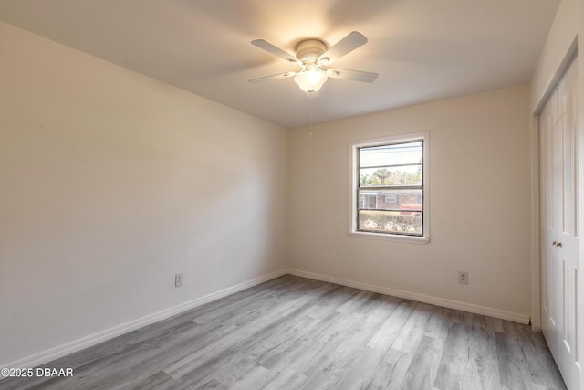 unfurnished room with wood finished floors, a ceiling fan, and baseboards