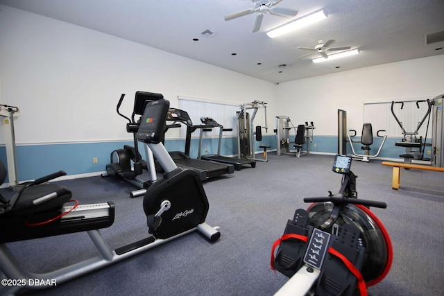 workout area with ceiling fan and a textured ceiling