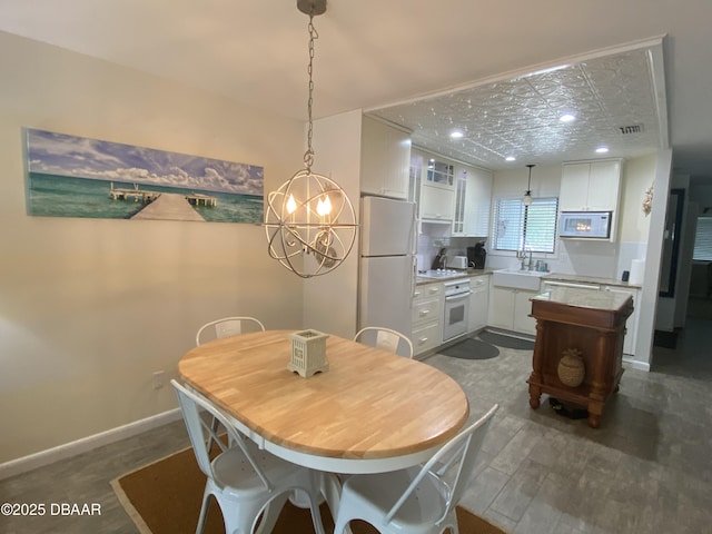 dining area featuring an inviting chandelier and sink