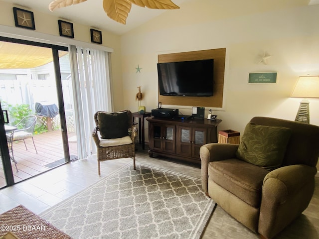 living room featuring wood-type flooring, vaulted ceiling, and ceiling fan