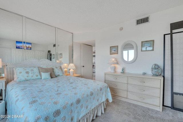 bedroom featuring light carpet and a textured ceiling