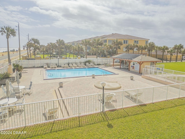 view of pool featuring a yard and a patio