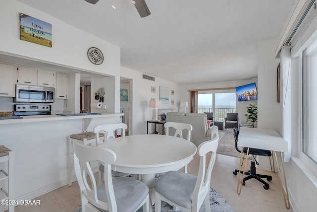 dining area featuring ceiling fan and light wood-type flooring