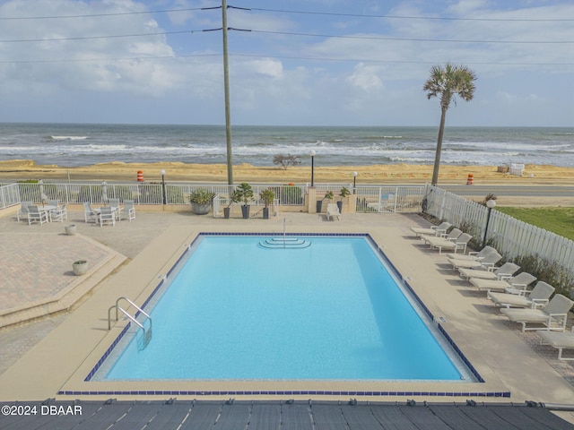 view of swimming pool with a patio area and a water view