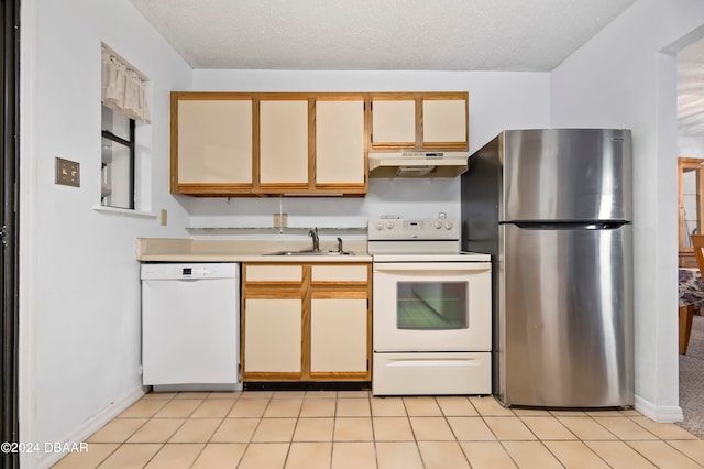 kitchen featuring light tile patterned floors, white appliances, a textured ceiling, and sink