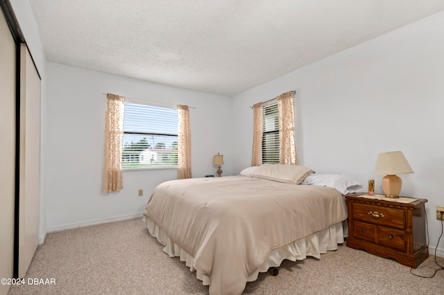 carpeted bedroom featuring a closet and a textured ceiling