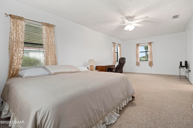 carpeted bedroom featuring a textured ceiling and ceiling fan