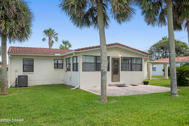 view of front facade featuring central AC unit, a patio area, and a front lawn