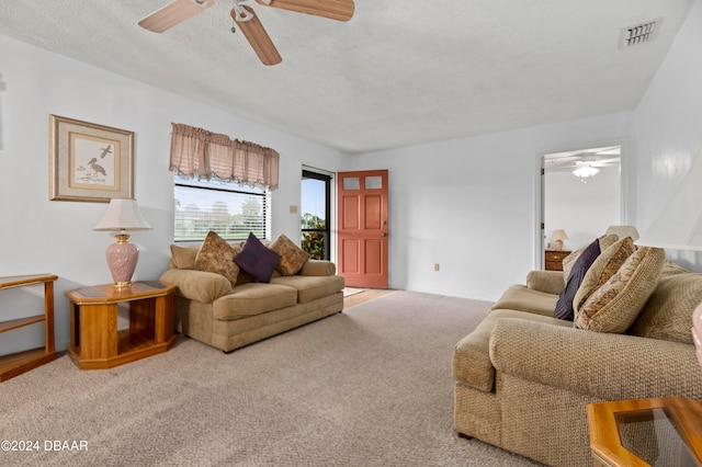 carpeted living room with a textured ceiling and ceiling fan