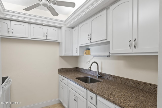 kitchen featuring sink, dark stone countertops, white cabinets, and ceiling fan