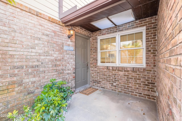 entrance to property featuring brick siding