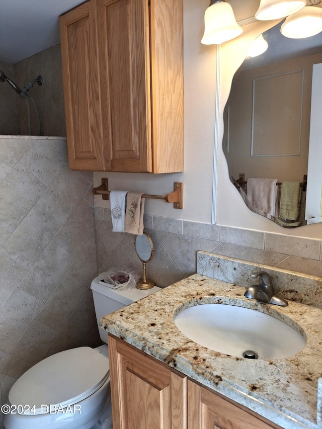 bathroom featuring tile walls, vanity, and toilet