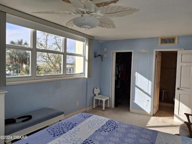 bedroom featuring a closet, a spacious closet, light colored carpet, and ceiling fan