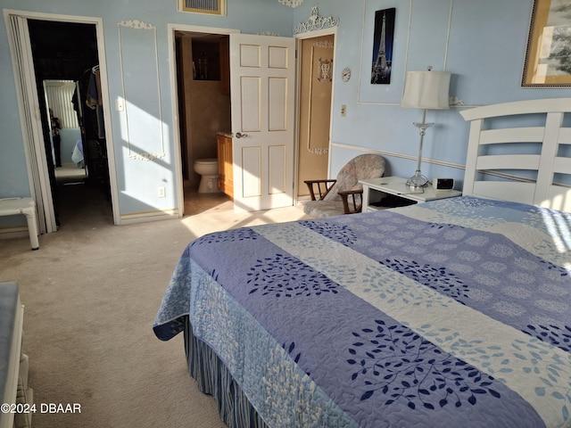 carpeted bedroom featuring ensuite bathroom