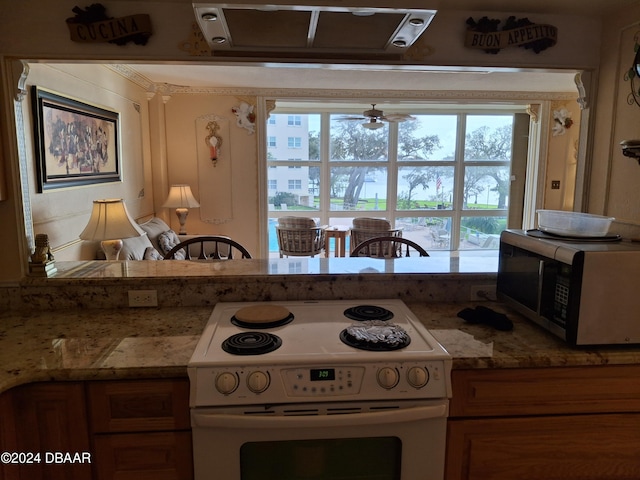 kitchen featuring white range with electric cooktop, ceiling fan, and light stone countertops