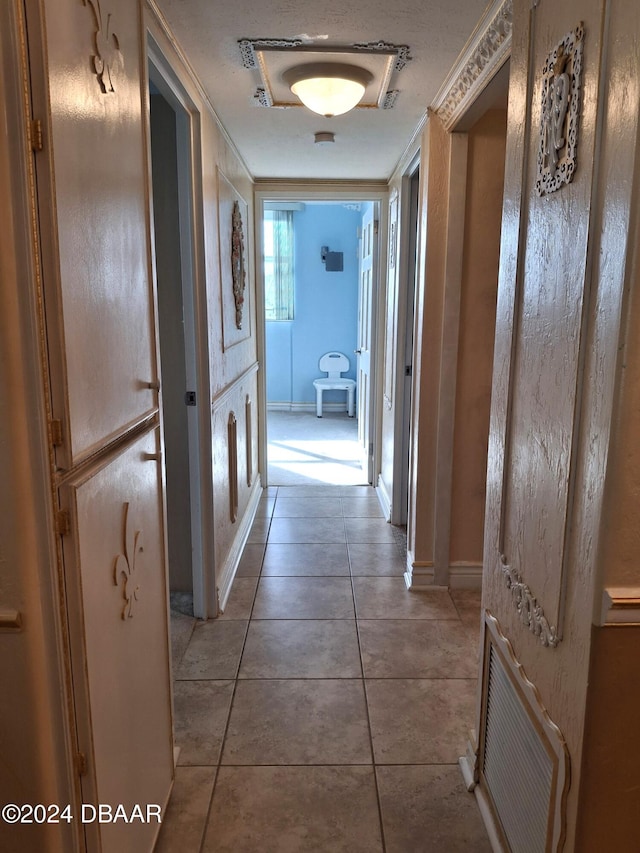 hallway with tile patterned flooring and a textured ceiling