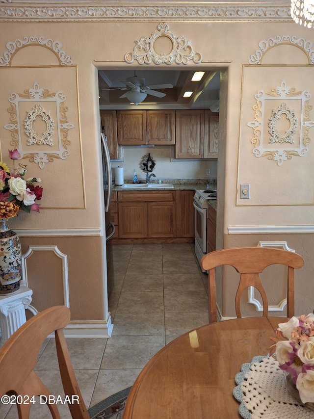 kitchen featuring sink, ceiling fan, light tile patterned flooring, electric range, and stainless steel fridge