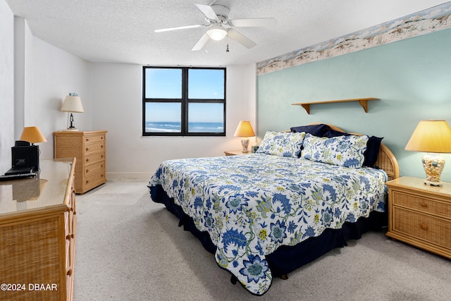 carpeted bedroom with a textured ceiling and ceiling fan