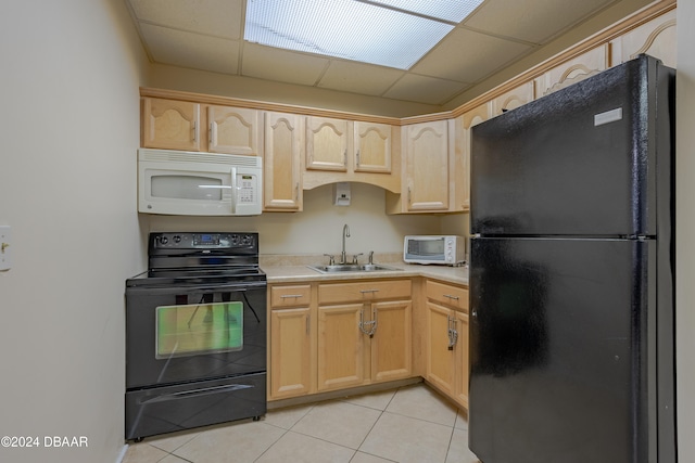 kitchen featuring sink, black appliances, a drop ceiling, light brown cabinetry, and light tile patterned floors