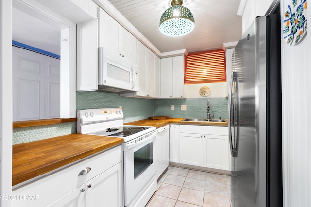 kitchen featuring sink, backsplash, white appliances, white cabinets, and butcher block countertops