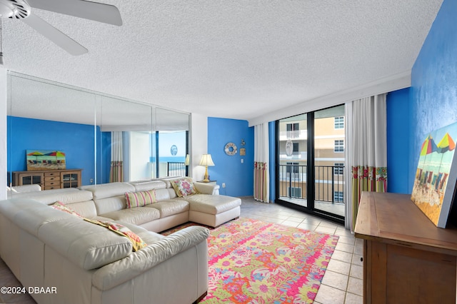 tiled living room featuring expansive windows, ceiling fan, and a textured ceiling